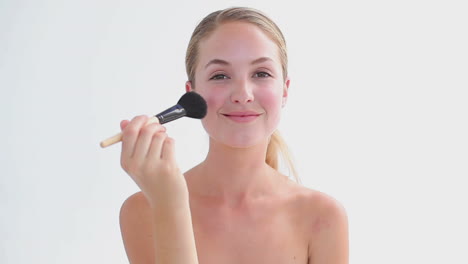 cheerful woman using a powder brush