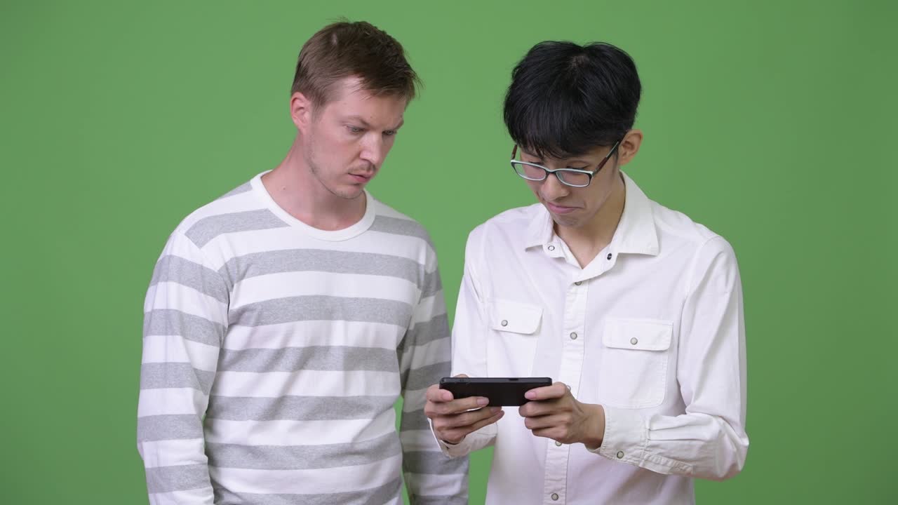 두 명의 젊은 다민족 사업가들이 함께 전화를 사용하고 있습니다.