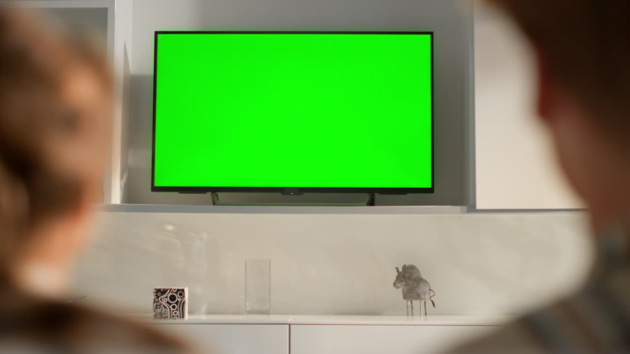 커플이 녹색 tv를 바꾸고, 알려지지 않은 가족이 주말에 함께 휴식을 취하고 있습니다.