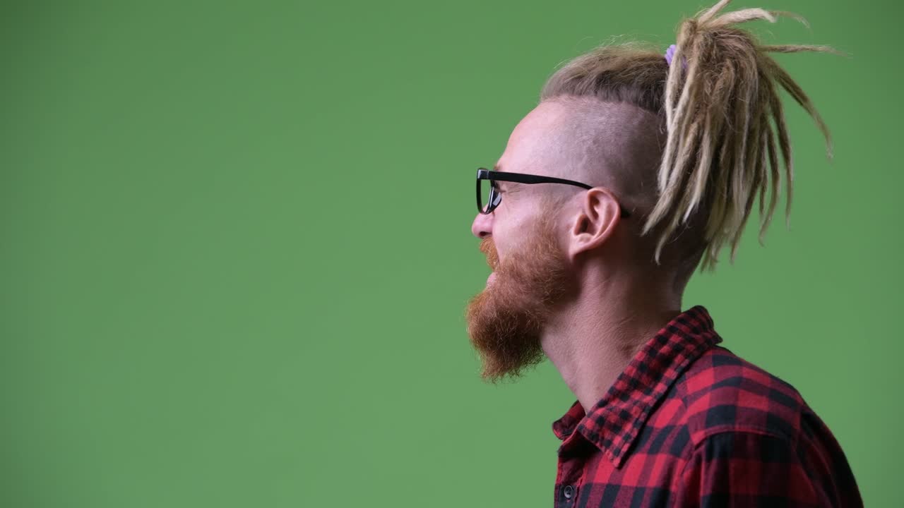 vista de perfil de un feliz hombre hipster barbudo con dreadlocks riendo