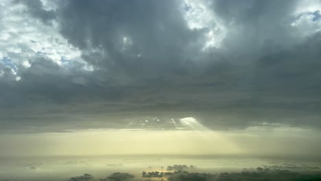 Aerial-view-of-dramatic-sky-with-rays-of-lifght-crossing-a-hole