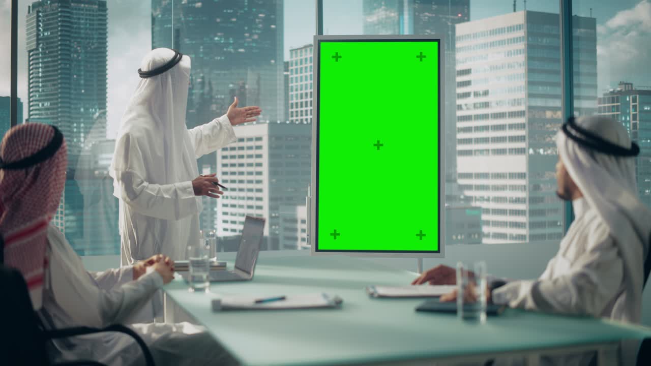 emirati empresario tiene una presentación de reunión para socios comerciales. gerente árabe utiliza pizarra digital con pantalla verde vertical maqueta de visualización. saudí, emiratí, concepto de oficina árabe.