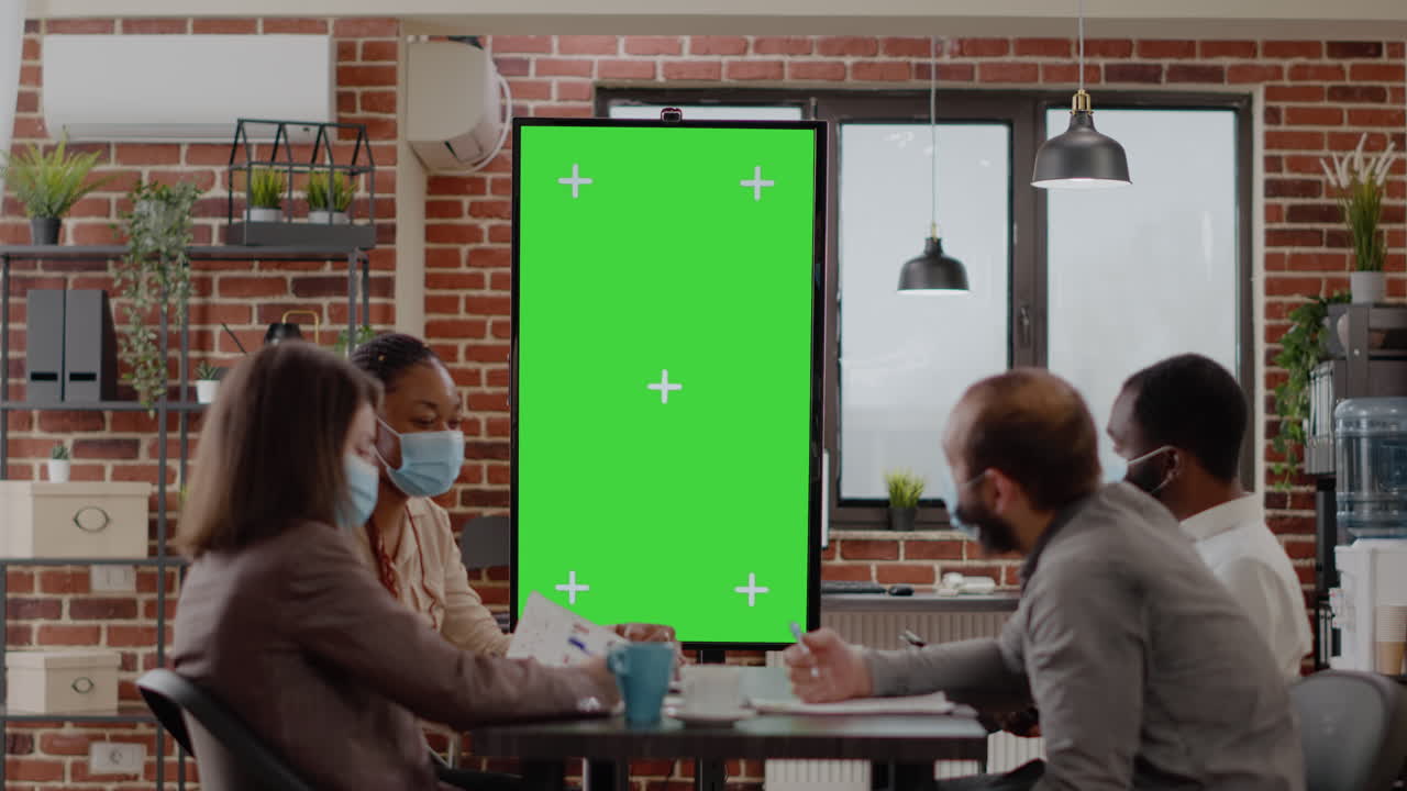 Team of colleagues working with vertically green screen