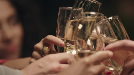 friends clink drink glasses together on group meeting celebration at restaurant.