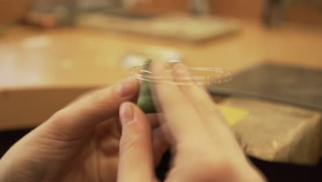 close-up shot of fixing greenstone from new zealand with silver wire - jewelry making