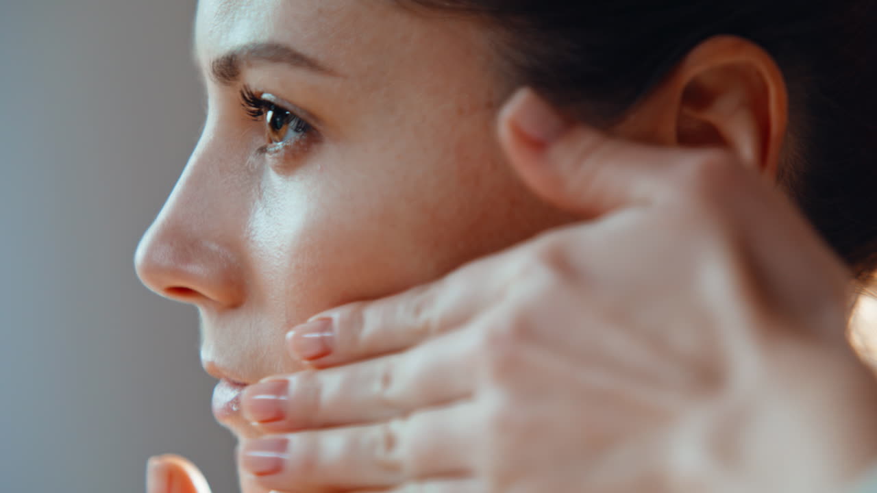 Closeup woman caring facial skin making self massage with hands in bathroom