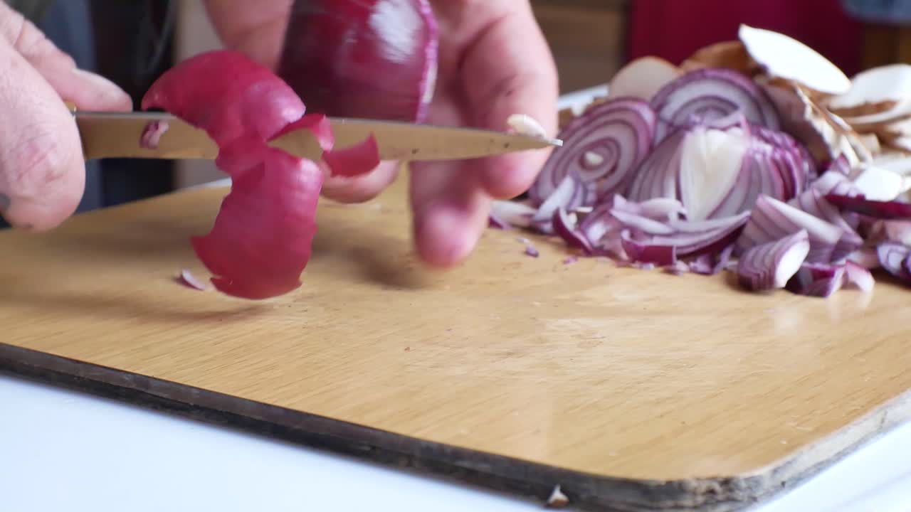 Close up on male hands preparing fresh red onion
