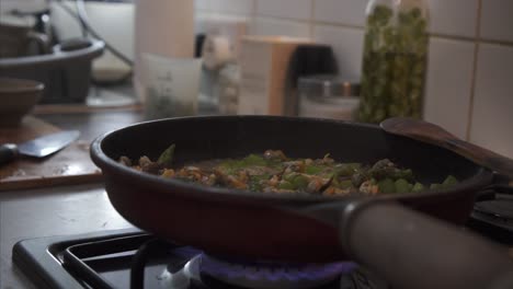 chef vertiendo vino sobre verduras salteadas