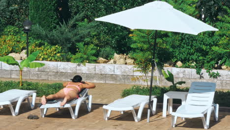 una joven sensual relajándose cerca de la piscina.