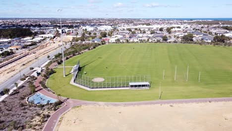 sweeping aerial view of football oval with ocean in background, near butler perth