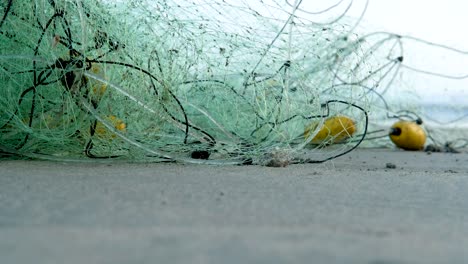 contaminación plástica del océano, red de pesca en la playa