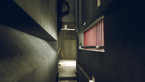 narrow alleyway with concrete walls, stairs and a red window