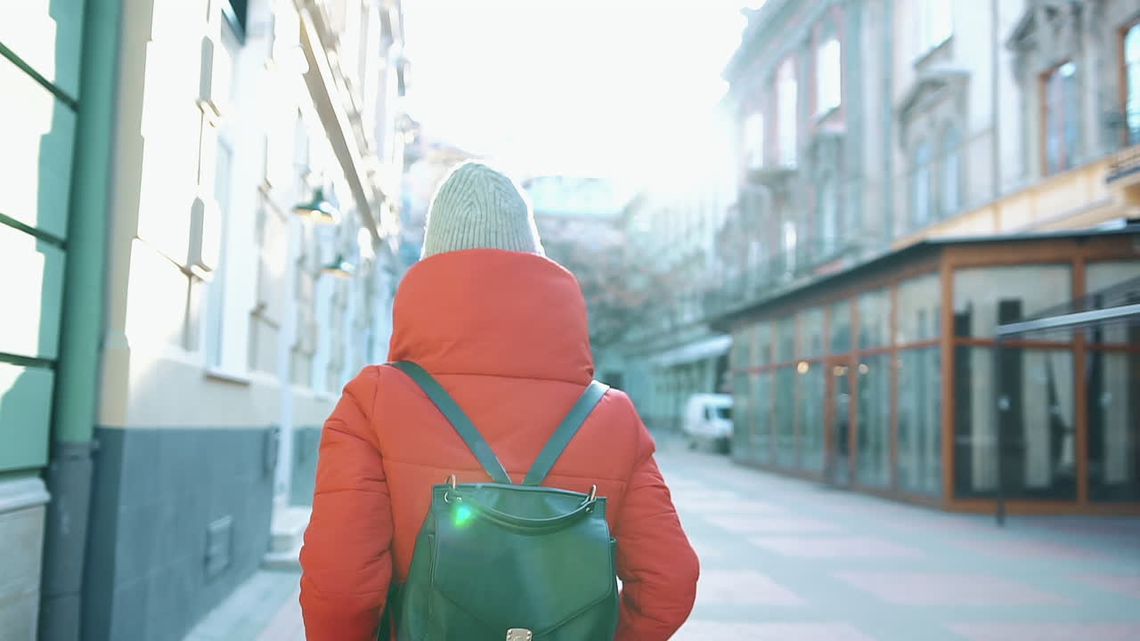 Woman walking down a city street in winter