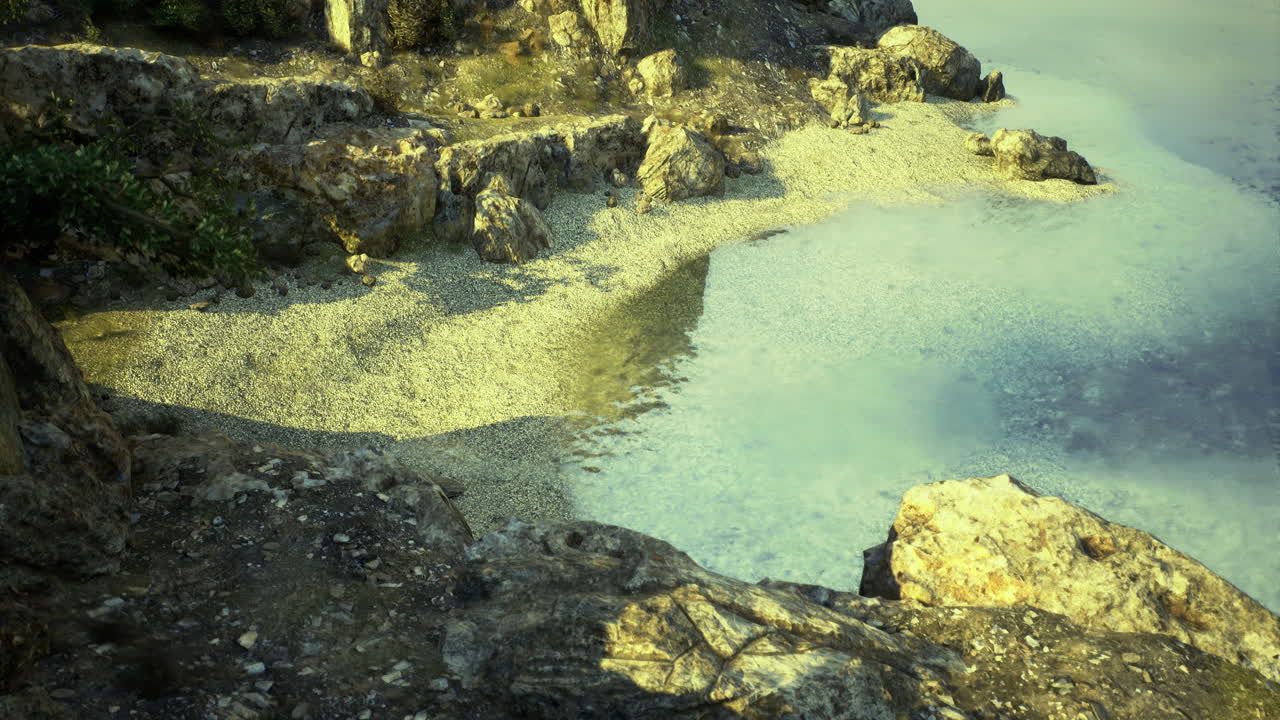 Coastal view of sandy beach and rocks in bright sunlight