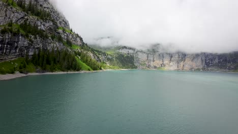 Vuelo-De-Drones-Hacia-El-Paisaje-Montañoso,-Toma-Aérea-Sobre-Un-Lago-Azul-De-Oeschinen,-Suiza,-Europa