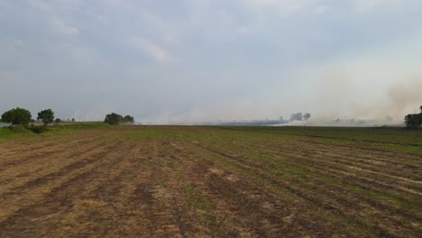 Imágenes-Aéreas-Justo-Sobre-El-Suelo-Labrado-Hacia-Una-Tierra-De-Cultivo-En-Llamas-Que-Se-Está-Preparando-Para-Plantar,-Quema-De-Pastizales,-Pak-Pli,-Nakhon-Nayok,-Tailandia