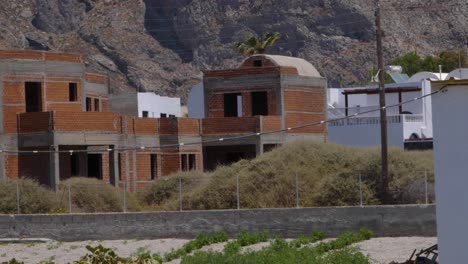 Handheld-Wide-Shot-of-an-Abandoned-Building-That-Was-Left-Under-Construction-in-Santorini,-Greece