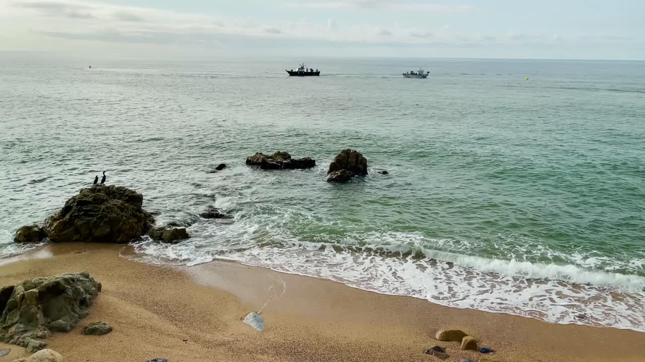 dos barcos de pescado playa mediterránea sin gente al amanecer azul turquesa aguas tranquilas costa de barcelona maresme costa brava españa turismo europeo