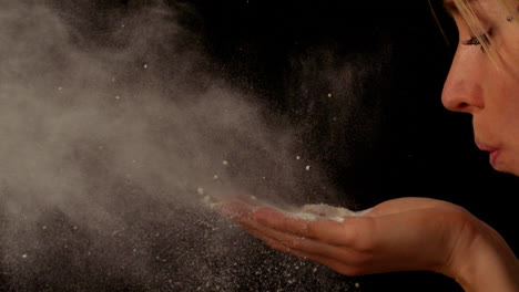 woman blowing flour from hands