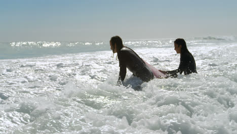 Surfer-couple-preparing-to-surf-on-the-wave-4k