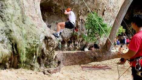 climber scaling rock with support in thailand