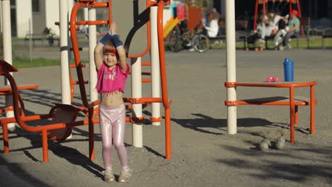 niña linda en ropa deportiva haciendo ejercicios de salto de fitness en el patio de recreo. entrenamiento para niños