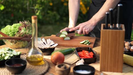 Plano-Medio-De-Un-Macho-Cortando-Calabacines-En-Rodajas-Largas-En-Su-Jardín