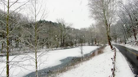 aerial flight in winter above frozen pond, lake