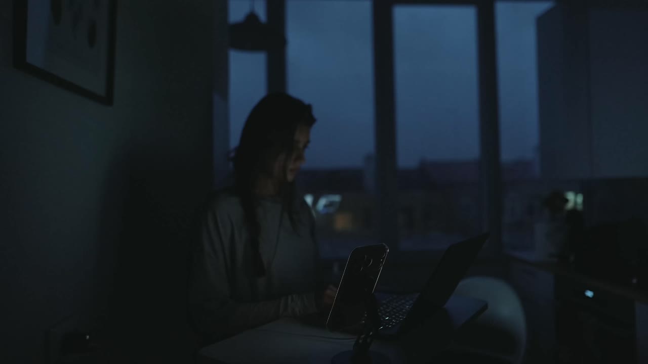 Woman working on laptop at night