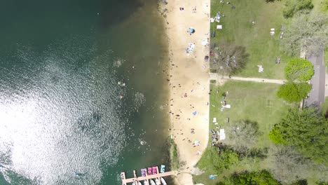 A-scarcely-populated-small-beach-on-a-lake-in-the-evergreen-covered-mountains-in-Wisconsin,-USA