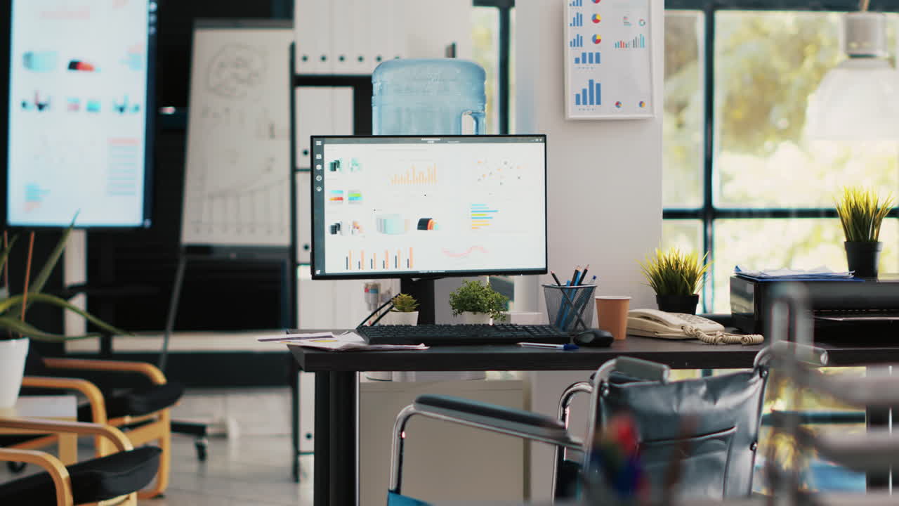 Wheelchair in inclusive office for workers and displays showing marketing charts
