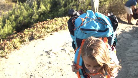 tired girl walking from parents on mountain path