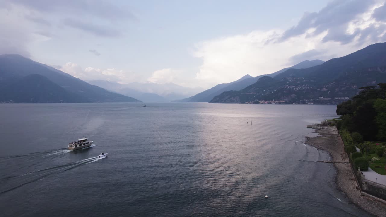 barcos navegando en el lago de como en bellagio, italia con un majestuoso paisaje montañoso