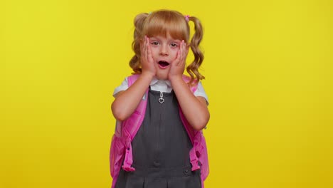 pretty teenage girl in school uniform raising hands in surprise , shocked by sudden victory, wow