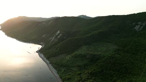 Beautiful-sunset-over-the-wooded-cliff-and-the-Adriatic-Sea,-aerial-view-from-a-drone