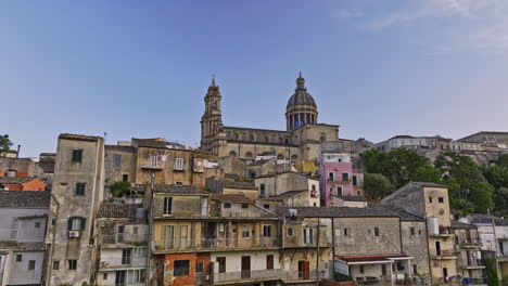 ragusa italy aerial v7 drone fly around the hill, tracking shot along the residential townhouses capturing charming ibla town and hilltop duomo di san giorgio - shot with mavic 3 cine - june 2023