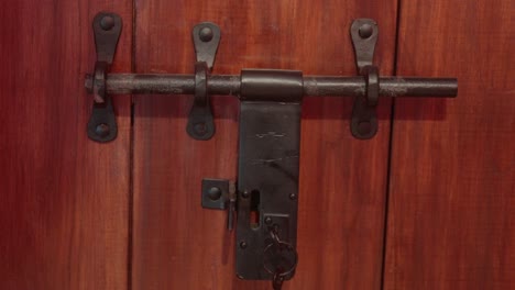 close-up of a black metal door lock on a wooden door
