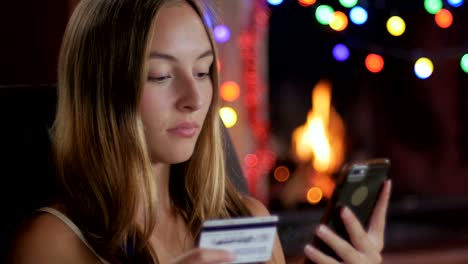 una compradora feliz completa sus compras de navidad con su teléfono - toma de muñeco