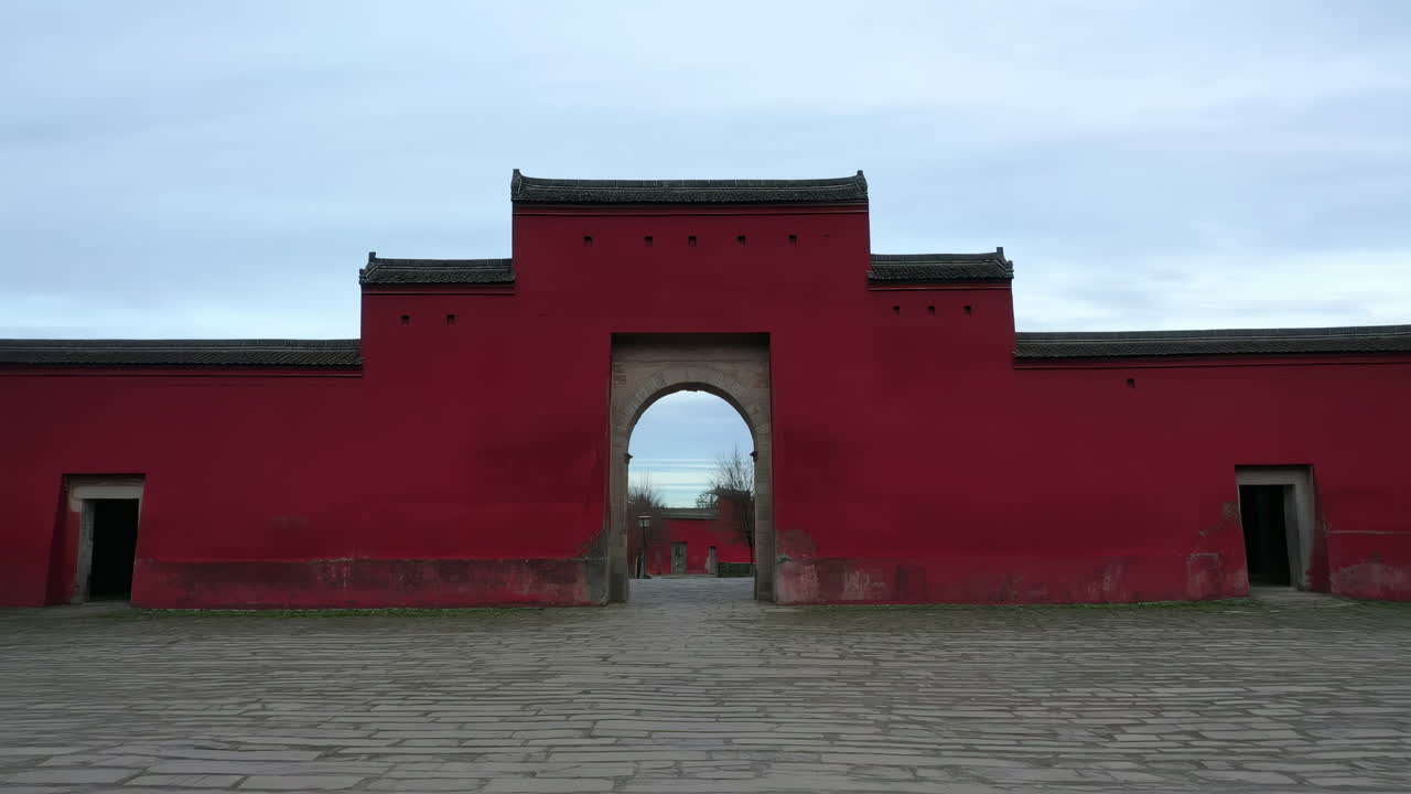 Traditional Chinese Red Wall with Arched Gateway Leading to Another Archway