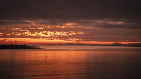 Day-to-night-time-lapse-of-Punta-del-Este-beach-at-sunset-with-rippled-ocean-surface-and-Gorriti-island-in-background,-Uruguay