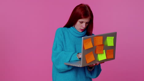 exhausted woman freelancer with pasted sticker notes using laptop computer, concentration problem