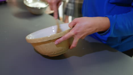 a woman mixing in a bowl cake mixture with flour butter and sugar