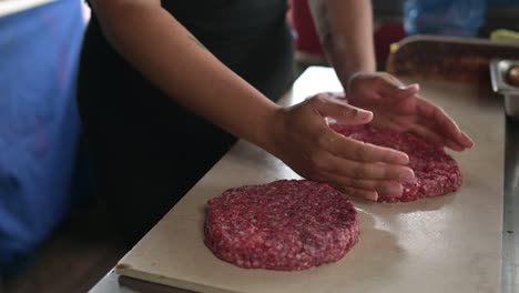 kulturkoch, der koteletts aus rohem hackfleisch zubereitet