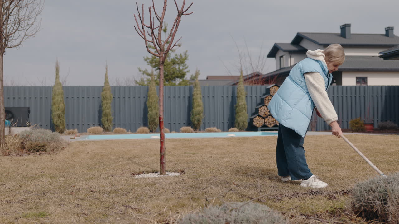 Woman raking leaves in the garden