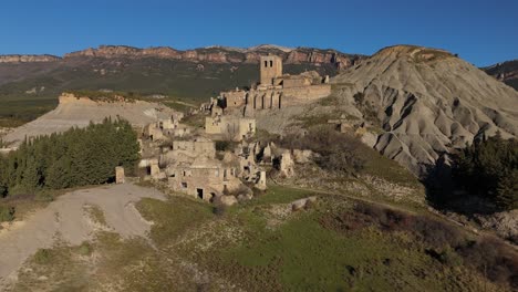 Ascending-drone-movement-and-revealing-the-abandoned-village-of-Escó,-Spain