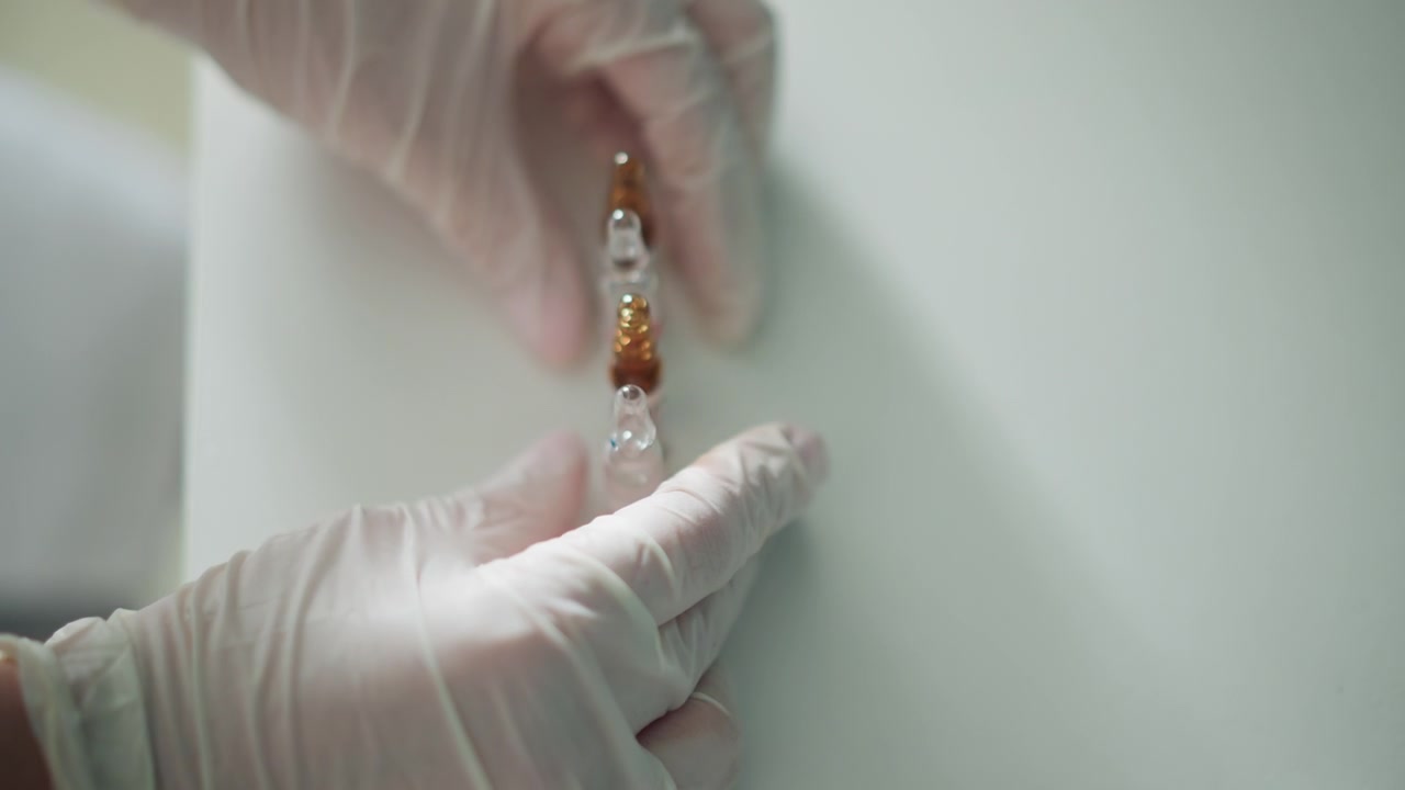 Ispezione di fiala sotto la luce. Mani guantate esaminano un campione di fiala in un ambiente di lavoro pulito. Ispezione sterile del campione di fiala sotto illuminazione analitica per la garanzia di qualità.