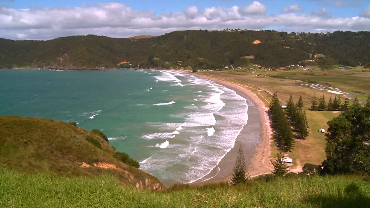 파도가 뉴질랜드 해변에서 해변으로 씻다