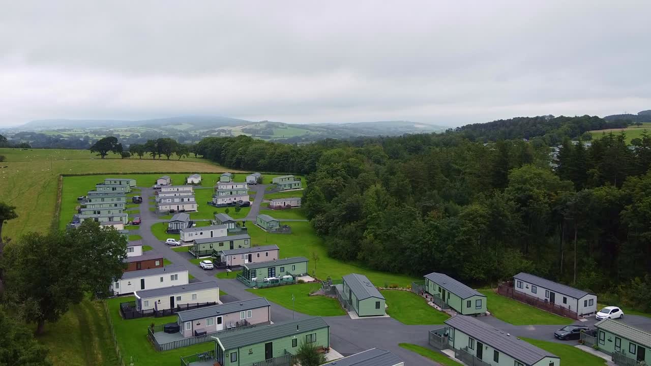 Rising aerial shot of caravan park in UK countryside on cloudy day