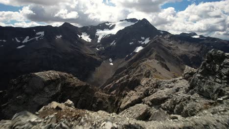 disparo dinámico aéreo sobre la cumbre de la montaña rocosa, revela un paisaje alpino dramático
