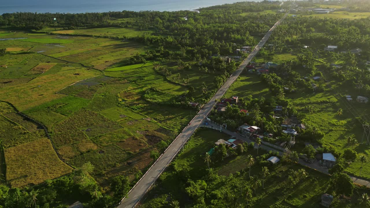 Picturesque Hyperlapse drone shot of quaint barangay village with tropical island foliage and provincial road - Timbaan, Catanduanes, Philippines